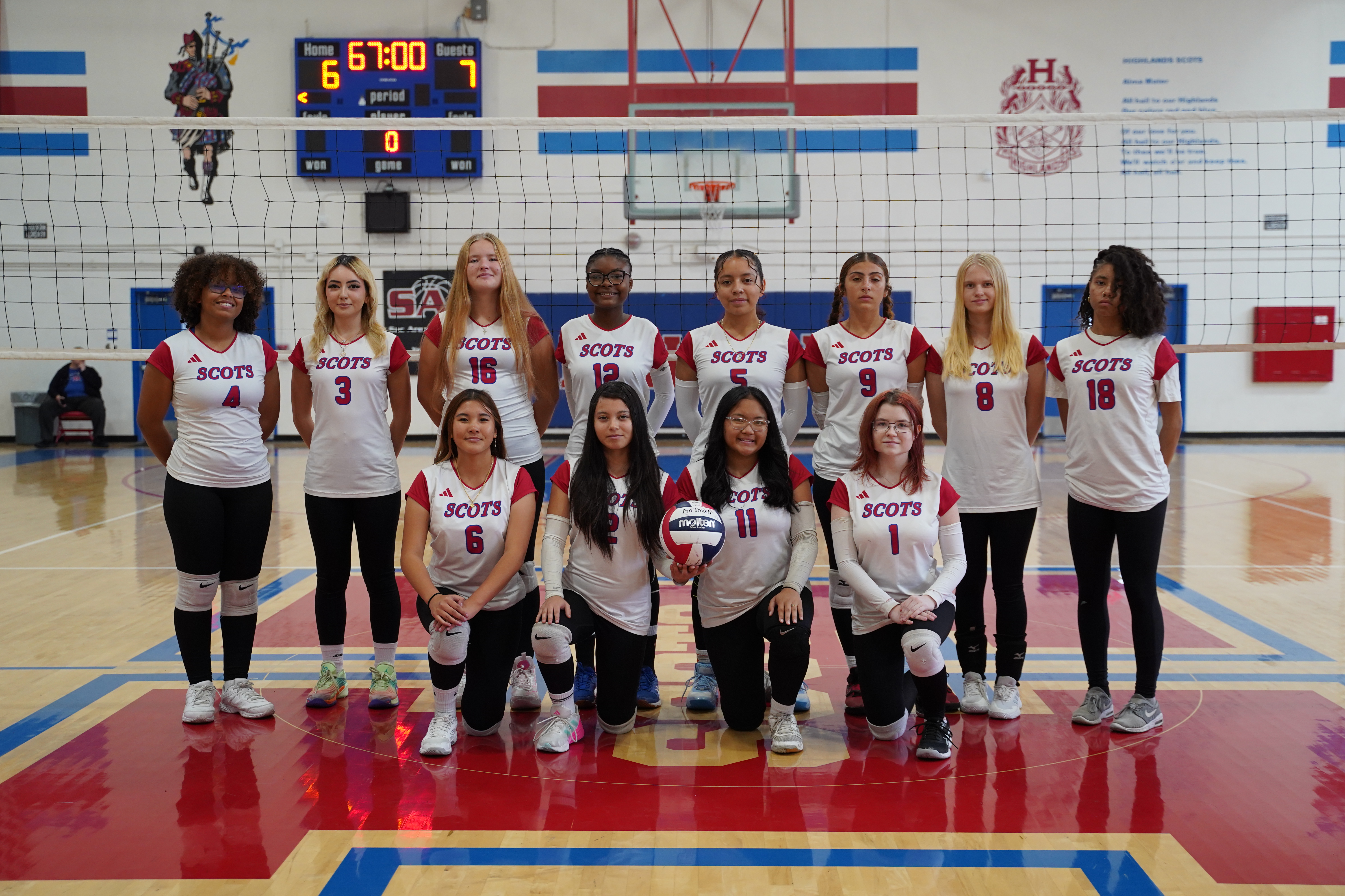 VARSITY GIRLS VOLLEYBALL TEAM  IN FRONT OF NET