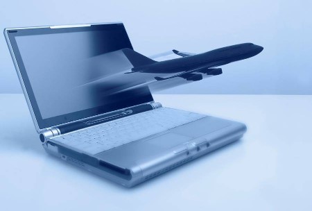 a laptop computer with an airplane flying out of it